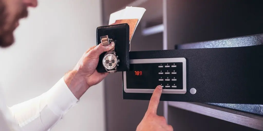 A human hand with holding a wallet and a watch with opened digital safe